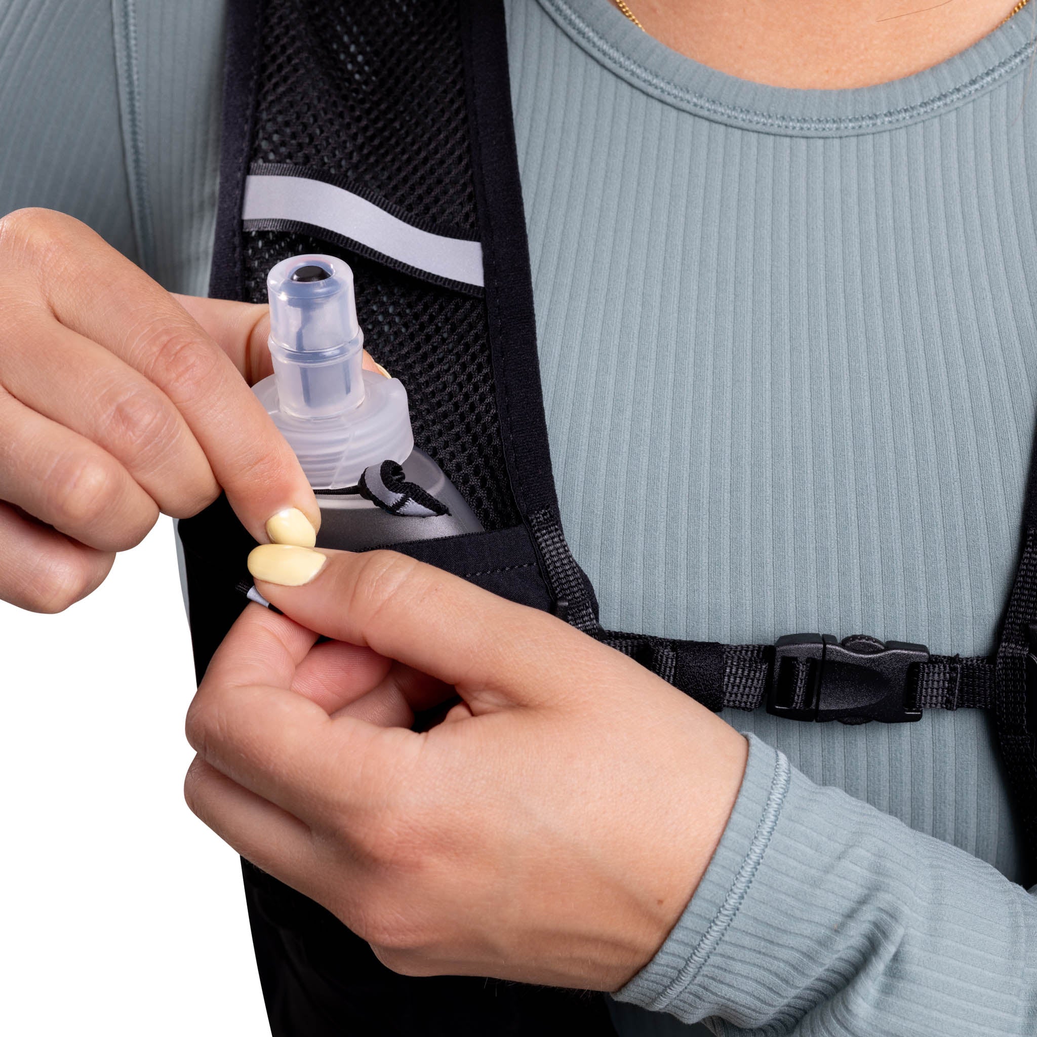 Person holding a small container and a pill, with a backpack in the background