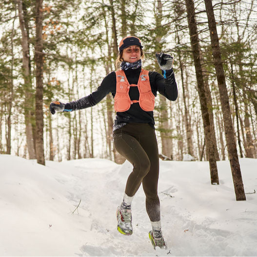 Person ice skating on a snowy path in a forest