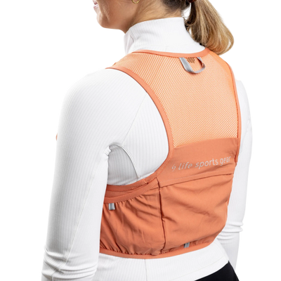 Person wearing an orange sports vest with a visible brand logo on a white background #color_terra-cota