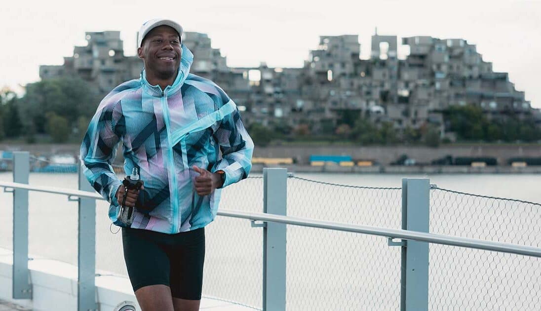 A runner near the water with a good form to avoid injuries