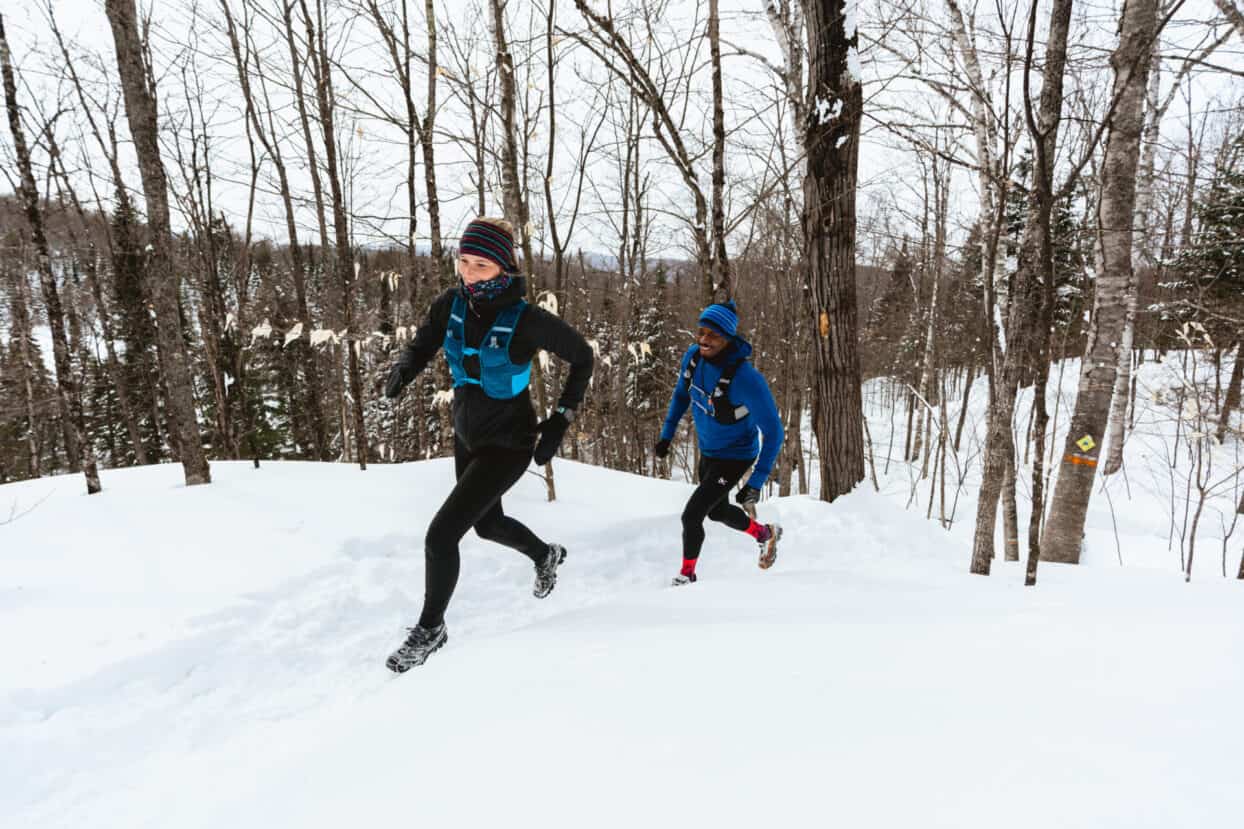 Une femme et un homme portent des crampons pour la course en sentier, en hiver