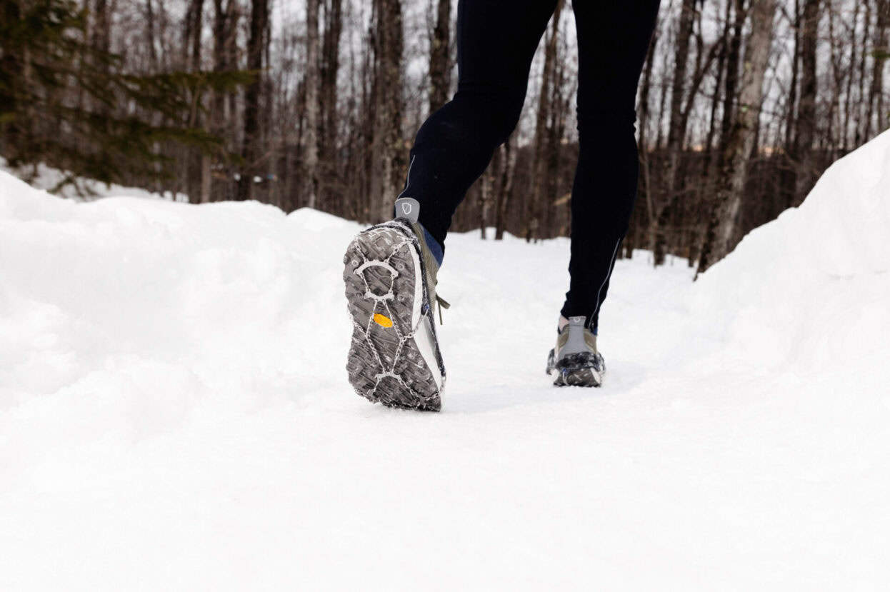 Gros plan sur les crampons utilisés pour la randonnée dans un sentier enneigé