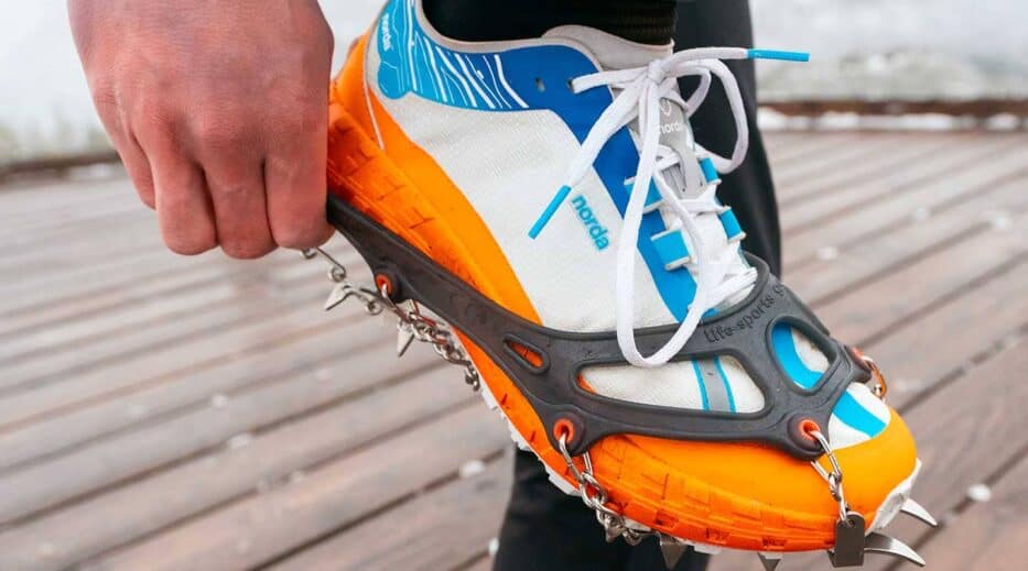 Crampons fixés à des chaussures de sport pour marcher l’hiver en toute sécurité